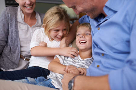 Feeling so loved by his family. A happy little boy laughing while spending time with his family.