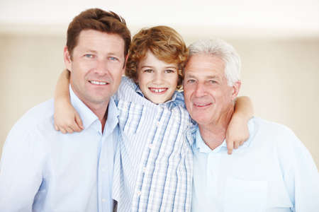 Whos under whos wing now. Cropped portrait of a young boy standing with his father and grandfather.