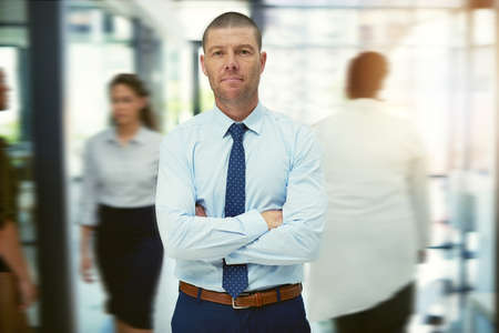 Success is something you need to keep in motion. Portrait of a mature businessman standing in a busy...