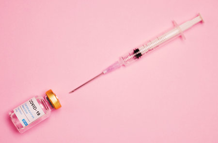 Extract the liquid to provide protection. Studio shot of a vaccine tube and syringe against a pink background.の写真素材