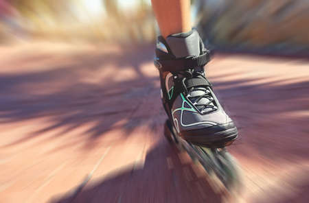 Cruising along. Closeup shot of a young womans feet in rollerblades speeding down a park path.の写真素材