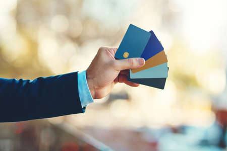 Theres one to suit your individual needs. Closeup shot of an unidentifiable businessman holding a selection of credit cards.の写真素材