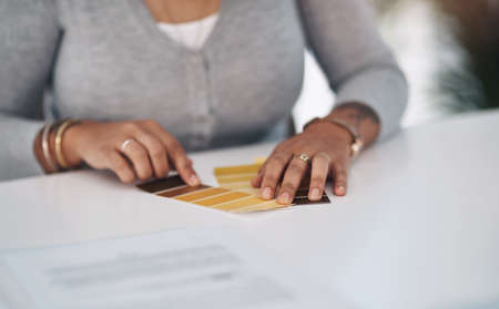 I quite like this colour here. Cropped shot of an unrecognizable businesswoman sitting alone in her office and looking at a colour swatch.の写真素材