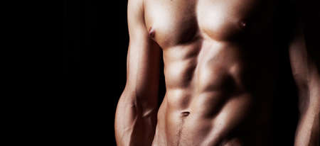 Masculinity in portrait. Studio shot of a muscular shirtless man isolated on black.