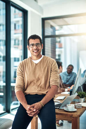 I lead the way for everyone else. Shot of a designer posing in the office with colleagues blurred in...