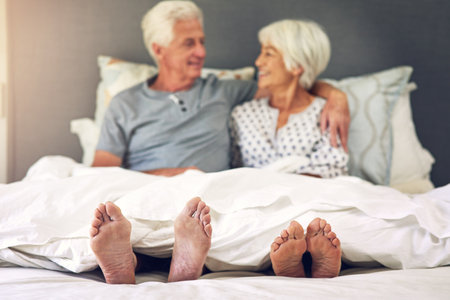Waking up next to you is priceless. Shot of a senior couple lying in bed.の写真素材