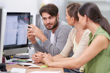 Working together to make the project a success. Shot of a group of young businesspeople talking at...