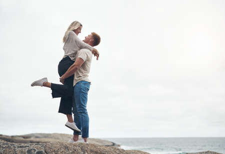 We met where the sky meets the ocean. Shot of a young couple spending the day together at the beach.