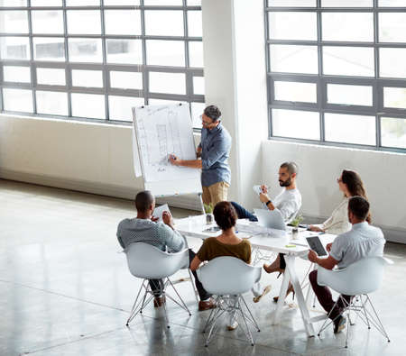 Communicating his ideas to the team. High angle shot of a group of businesspeople meeting in the...