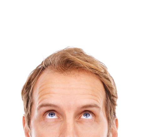 Hmmm... very interesting. Cropped shot of the upper half of a young mans face looking up at copyspace.の写真素材