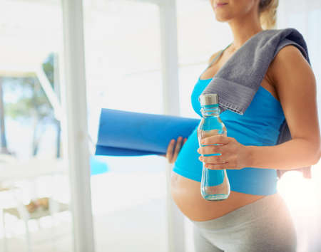 Geared up for a healthy pregnancy. Cropped shot of a pregnant woman getting ready to workout at home.の写真素材
