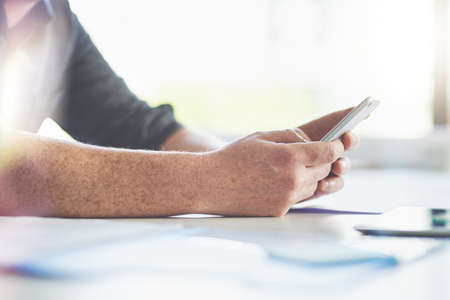 Digitizing the workday. Closeup shot of an unrecognizable businessman texting on a cellphone in an...
