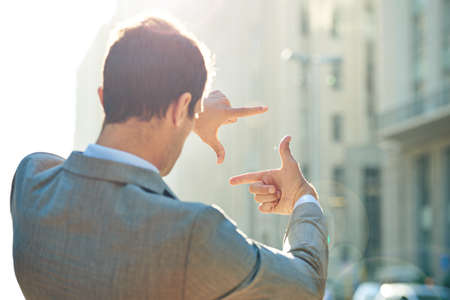 Hes a man of vision. Shot of a businessman framing a city scene with his hands.の写真素材