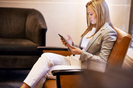 Where to go next. Shot of a young woman sitting in a chair using a digital tablet.