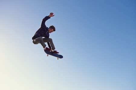 A rad day at the skate park. A young man doing tricks on his skateboard at the skate park.