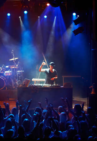 A DJ playing his live set to a group of screaming fans. This concert was created for the sole purpose of this photo shoot, featuring 300 models and 3 live bands. All people in this shoot are model releasedの写真素材