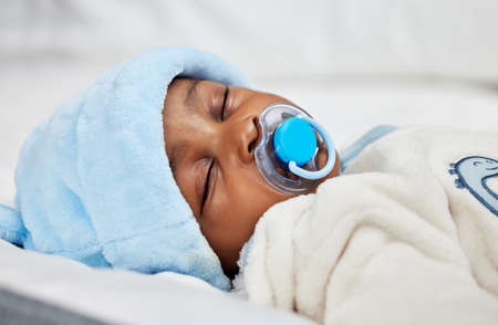 Everyone loves nap time. Shot of a baby boy sleeping on a bed.