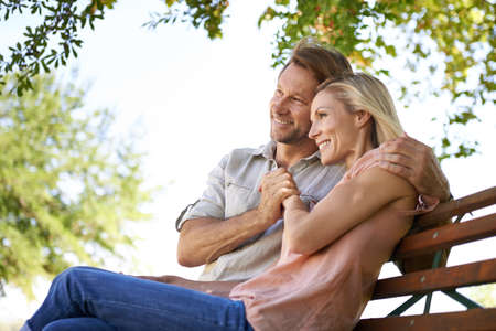 Love is inspired by the simplicity of nature. Shot of a happy mature couple sitting on a bench in...