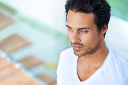 Hes clam and collected. A handsome young man sitting with his back agains a pane of glass.の写真素材
