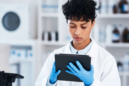 Digitising some of her work for more efficient results. Shot of a young scientist using a digital...