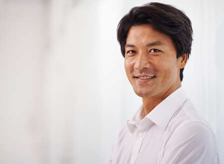 Hes got what it takes to be a leader. Portrait of a handsome businessman smiling at the camera.の写真素材
