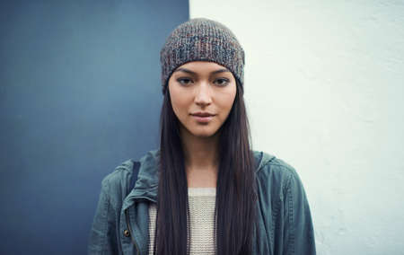Shes a confident woman. Portrait of a young woman standing outdoors.の写真素材