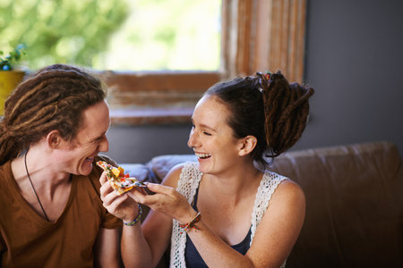 Theres nothing as tasty as pizza. Shot of a Rastafarian couple eating pizza.の写真素材