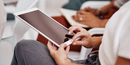 Are you keeping up with the technological evolution. Closeup shot of an unrecognisable businesswoman using a digital tablet in an office.の写真素材