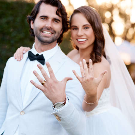 We just got married. Cropped shot of a newlywed couple showing off their wedding rings.の写真素材