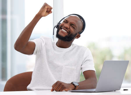 Yes i achieved my goals for the day. Shot of a male businessman working in a call center.の写真素材
