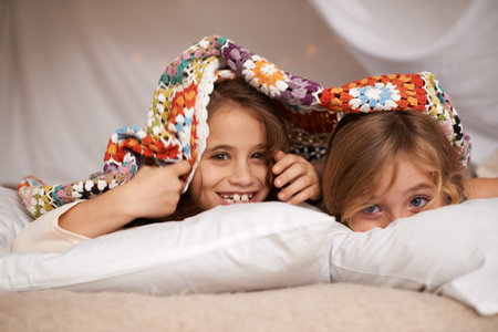 Sleepover fun. Shot of two cute little girls having a sleepover.の写真素材