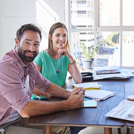 Well achieve success together. Cropped portrait of two young designers sitting in the boardroom.の写真素材
