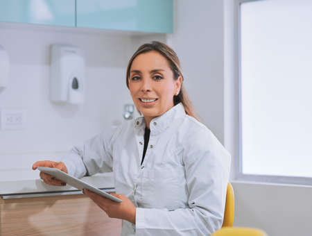 Looking after your oral health. Portrait of a cheerful young female dentist working on her digital...