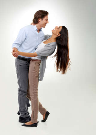Hell never let her fall. A multi-ethnic couple dancing isolated on a white background.の写真素材