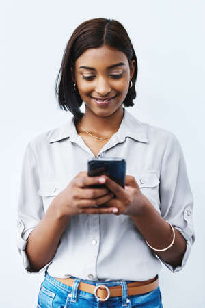 When you get that message that brightens up your day. Studio shot of a young creative businesswoman...