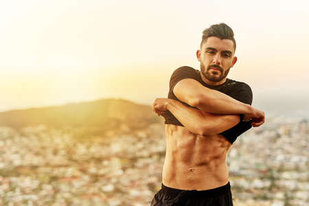 Flaunt what you worked hard for. Shot of a young man exercising outdoors.