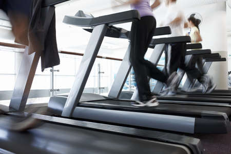 And theyre off. Cropped shot of a people running on the treadmills at the gym.の写真素材