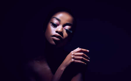 Let us live for the beauty of our own reality. Studio shot of a young woman posing against a black background black background.の写真素材