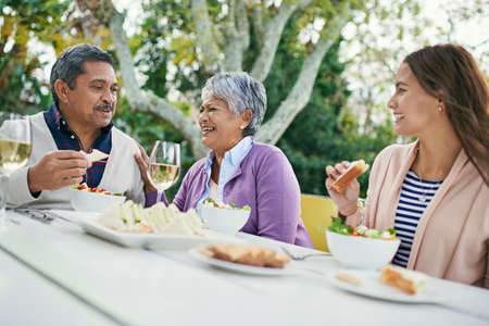Dads jokes have them rolling in the aisles. Cropped shot of a family enjoying lunch and wine...