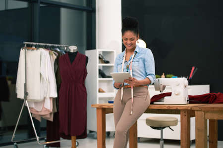 Keeping up with the latest trends. Shot of a fashion designer working on her digital tablet.