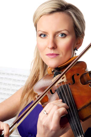 Her passion for music is reflected in her dedication. Studio shot of a beautiful young woman playing the violin.の写真素材