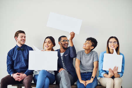 Lets put whats on our minds on a message. Shot of a diverse group of creative employees holding up speech bubbles inside.の写真素材