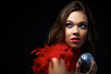 Sultry songstress. Shot of an attractive young singer holding an old-fashioned microphone.