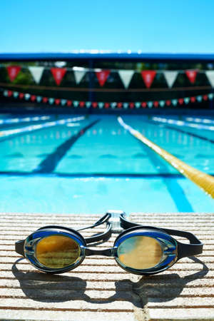 Swimming gear. Closeup shot of goggles on the poolside.の写真素材