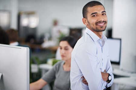 Hes got business accumen. Cropped shot of a handsome businessman sitting on his desk with a few...