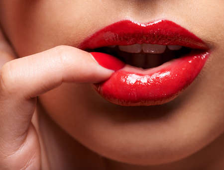 Desire comes in red. Cropped shot of a woman pressing her finger against her lip.の写真素材