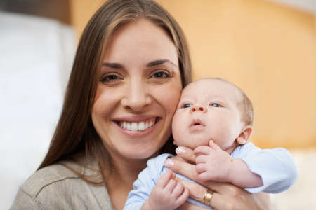 Isnt he cute. A young mother holding her newborn baby.