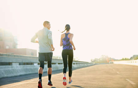 Nothing better than a morning run. Rearview shot of two friends jogging through the city.