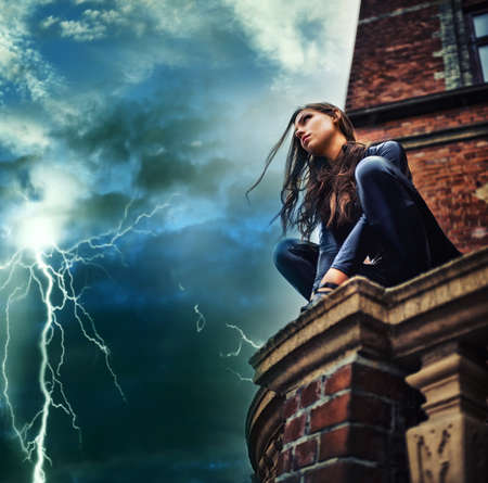 Shes a force of nature - Superhero. Seductive young woman in a black catsuit crouched on a rooftop...