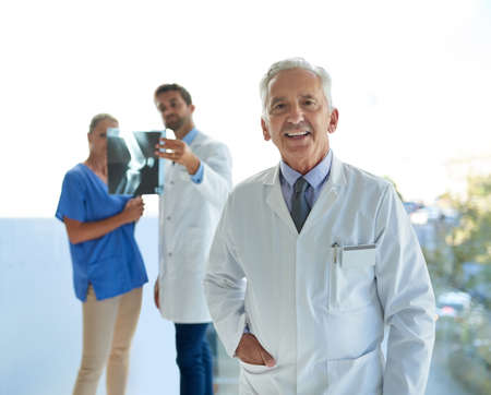 Were in it together for the good of your health. Portrait of a mature doctor standing in a hospital...